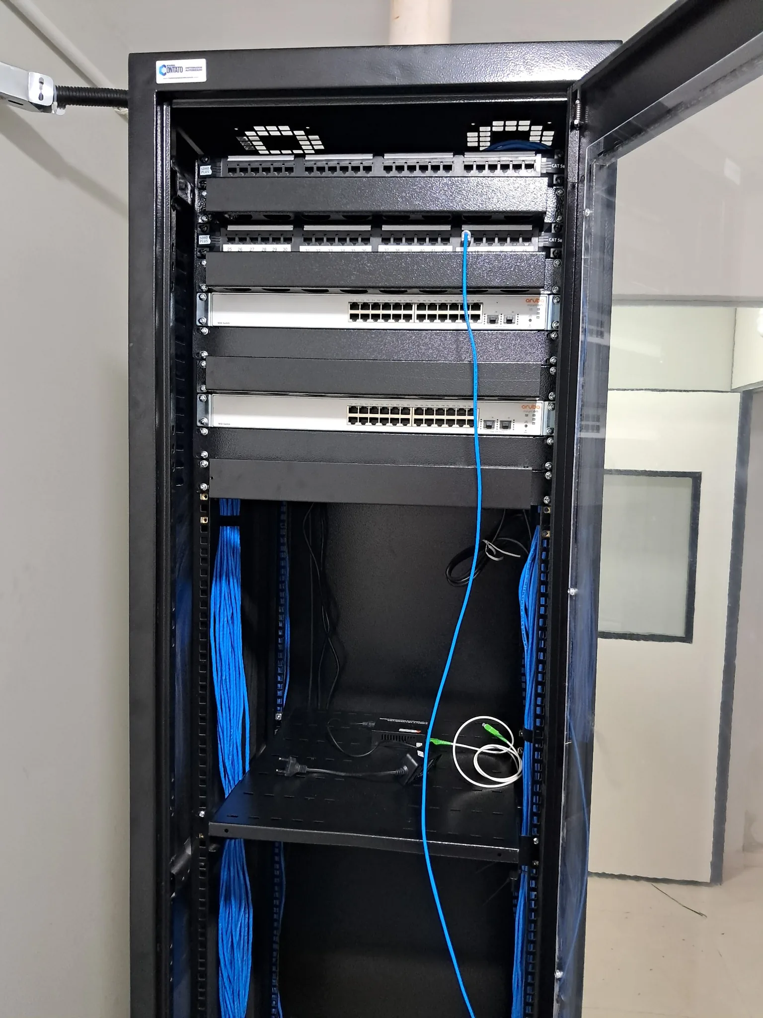 Rack corporativo com patch panels e switches instalado pela Keleuthos